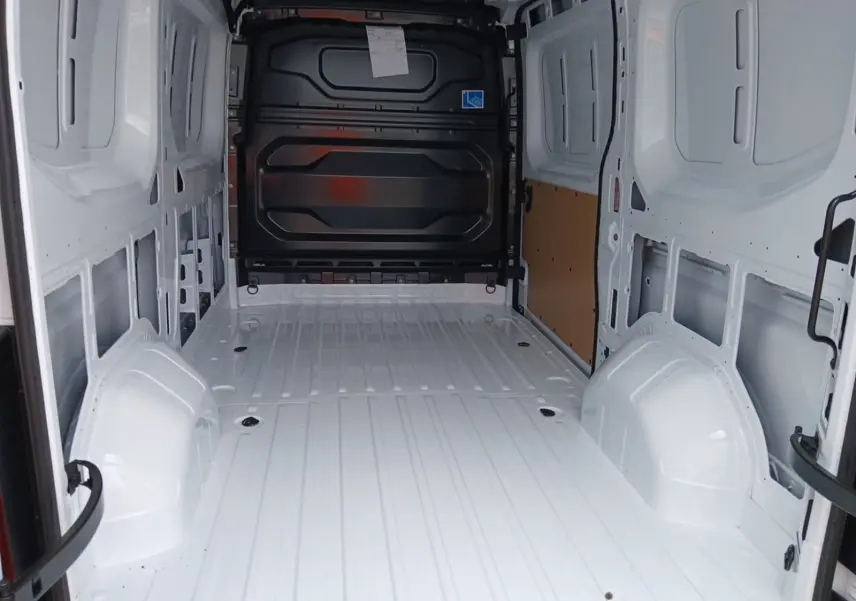 Vue intérieure arrière du Renault Master blanc L2H2 2026, montrant l'espace de chargement vide avec cloison noire.