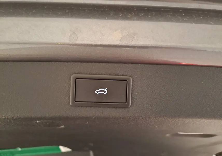 Bouton d'ouverture électrique du coffre sur la partie intérieure du hayon d'un Skoda Kodiaq gris graphite hybride rechargeable.