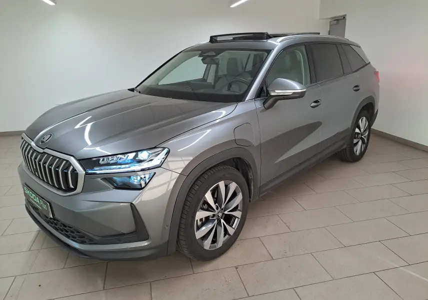 Vue 3/4 avant droite d'un Skoda Kodiaq gris graphite avec toit ouvrant panoramique et jantes alliage 19 pouces.