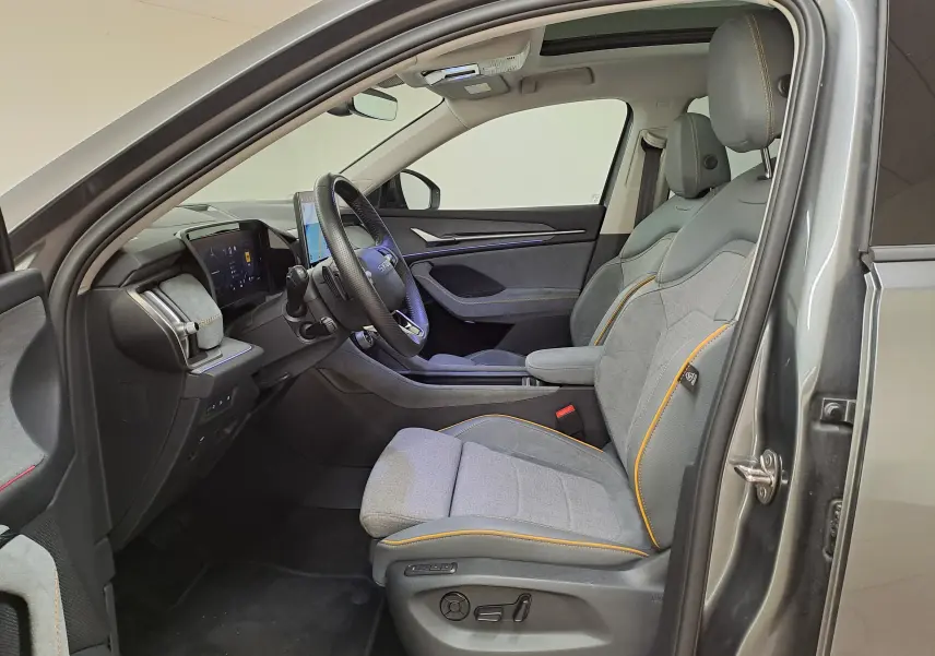 Vue intérieure côté conducteur du Skoda Kodiaq gris graphite 2025, sièges tissu et cuir avec surpiqûres orange.