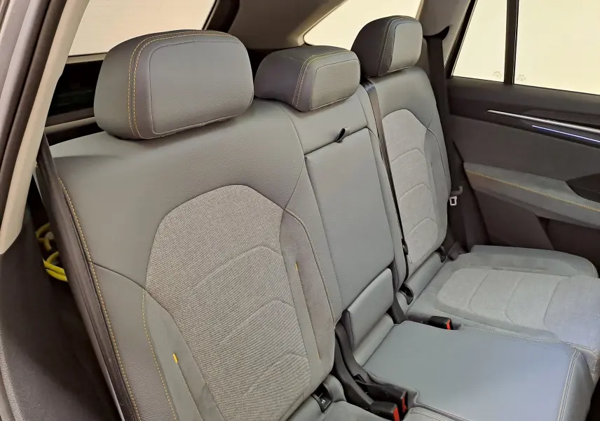 Vue intérieure sur la banquette arrière grise avec surpiqûres jaunes du Skoda Kodiaq 2025 hybride rechargeable.