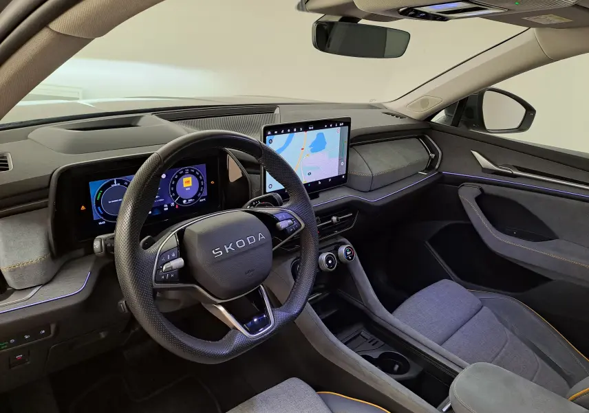 Vue intérieure côté conducteur du Skoda Kodiaq 2025, tableau de bord moderne avec écran tactile et volant marqué SKODA.