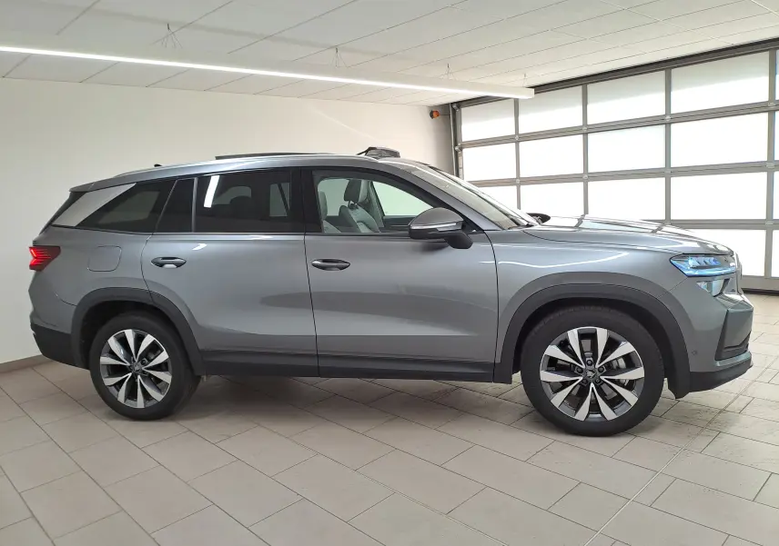 Vue de profil côté gauche d'un Skoda Kodiaq gris graphite 2025 avec jantes alliage 19'' Lefka et toit panoramique ouvrant.