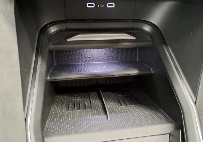 Détail de la console centrale du Skoda Kodiaq avec espace de rangement et ports USB éclairés.