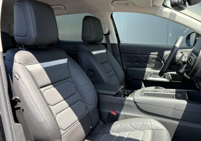 Vue intérieure côté conducteur du Citroën C5 Aircross Hybrid 2025, sièges Advanced Comfort en tissu et cuir noir avec surpiqûres.