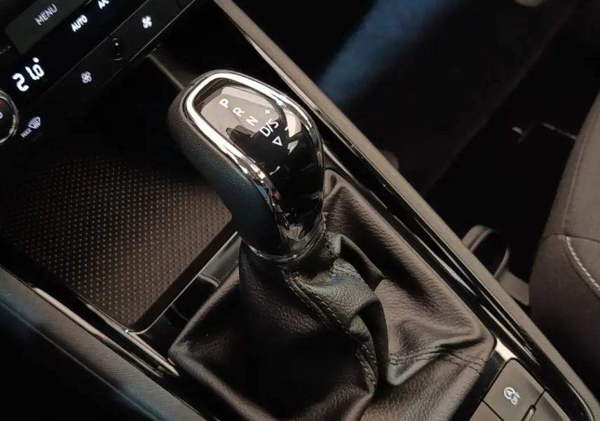 Gros plan sur le levier de vitesse automatique noir et chrome dans l’habitacle sombre d’une Skoda Scala 2025.