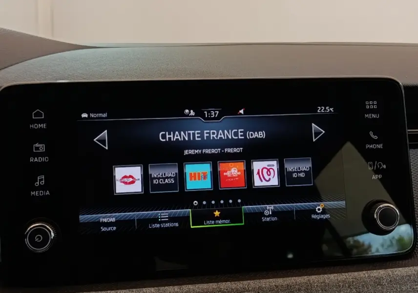 Écran tactile central de la Skoda Scala 2025 affichant la radio numérique avec menu et boutons latéraux visibles.