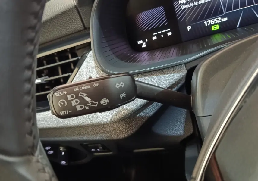 Gros plan sur la commande multifonctions à gauche du volant dans le tableau de bord gris d'une Skoda Scala 2025.