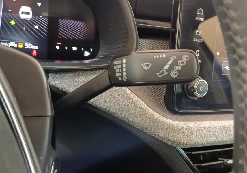 Gros plan sur la commande des essuie-glaces à gauche du volant dans l’habitacle du Skoda Scala bleu 2025.