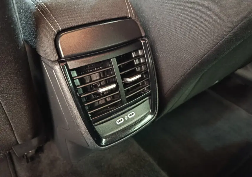 Vue rapprochée des aérateurs arrière noirs avec deux ports USB-C sur la console centrale arrière d'une Skoda Scala bleue.