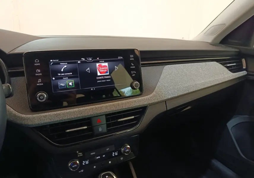 Vue intérieure côté passager du tableau de bord gris clair et écran tactile central de la Skoda Scala 2025.