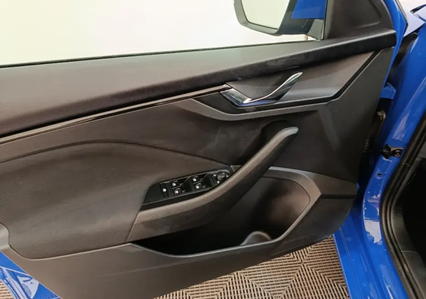 Vue intérieure côté gauche de la porte avant bleue d'une Skoda Scala avec commandes de vitres et poignée chromée.