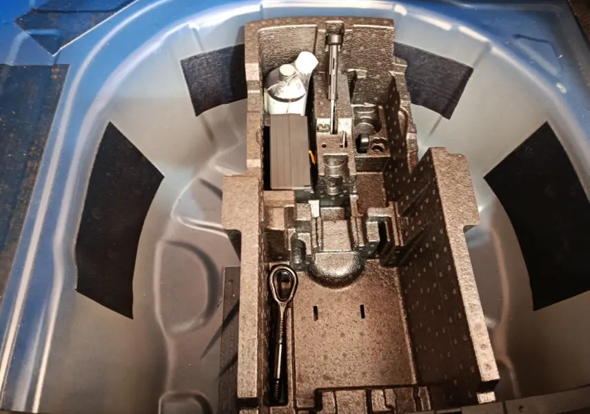 Vue plongeante sur la roue de secours galette et son rangement en mousse dans le coffre d'une Skoda Scala bleu 2025.