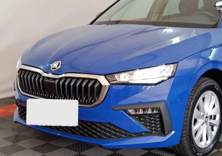 Vue avant droite d'une Skoda Scala bleu vif avec calandre noire et phares LED allumés.