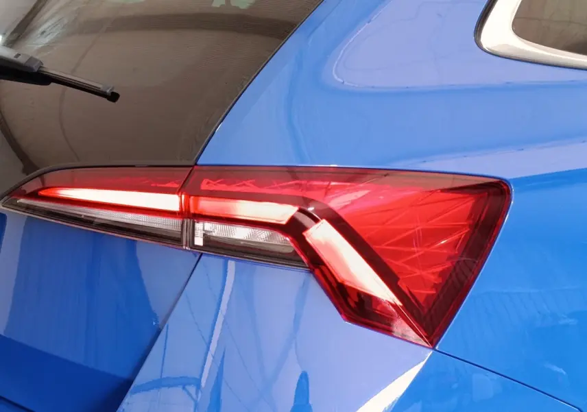 Gros plan sur le feu arrière droit rouge d’une SKODA SCALA bleu 2025, soulignant la ligne anguleuse de la carrosserie.