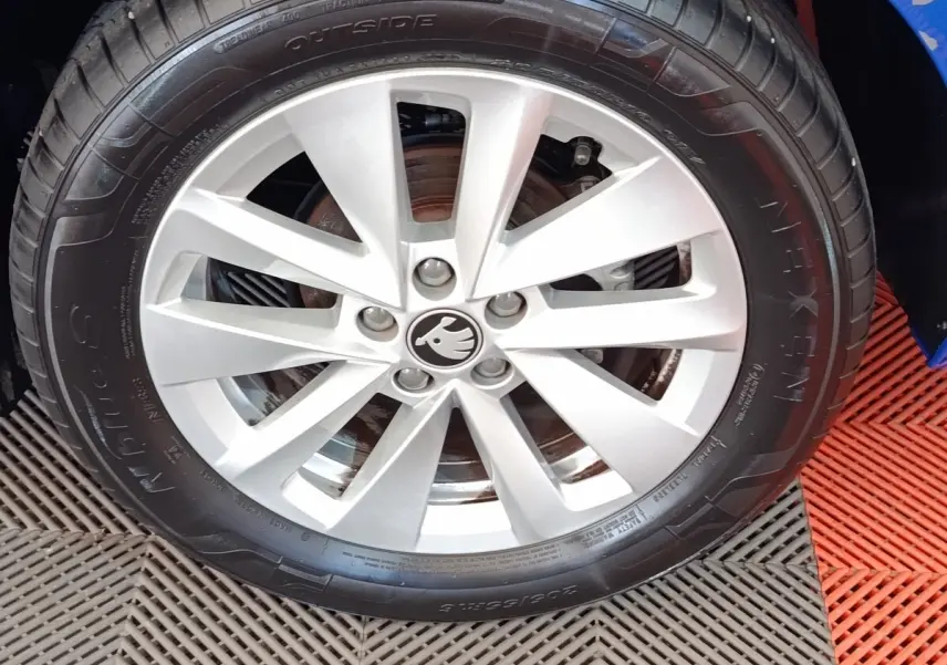 Gros plan sur la roue avant droite avec jante alliage argentée du Skoda Scala bleu 2025.