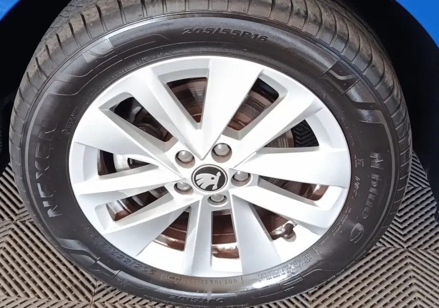 Gros plan sur la roue avant droite de la Skoda Scala bleue, mettant en valeur la jante alliage argentée et le logo central.