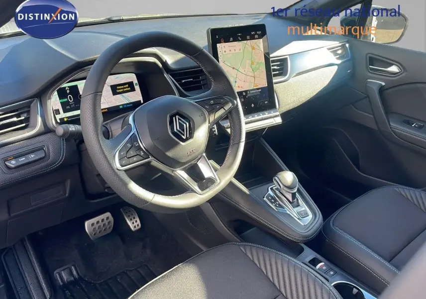 Intérieur du Renault Captur E-Tech hybride 2008, vue du poste de conduite avec écran tactile vertical et volant multifonction.