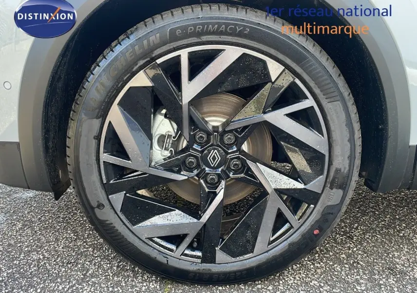 Gros plan sur la jante avant droite noire et argentée du Renault Captur gris Rafale métal avec logo Renault central.