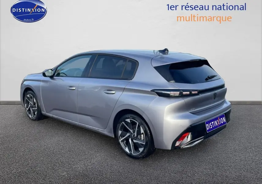 Vue 3/4 arrière droite d'une Peugeot 308 gris artense avec jantes alu et vitres arrière surteintées.