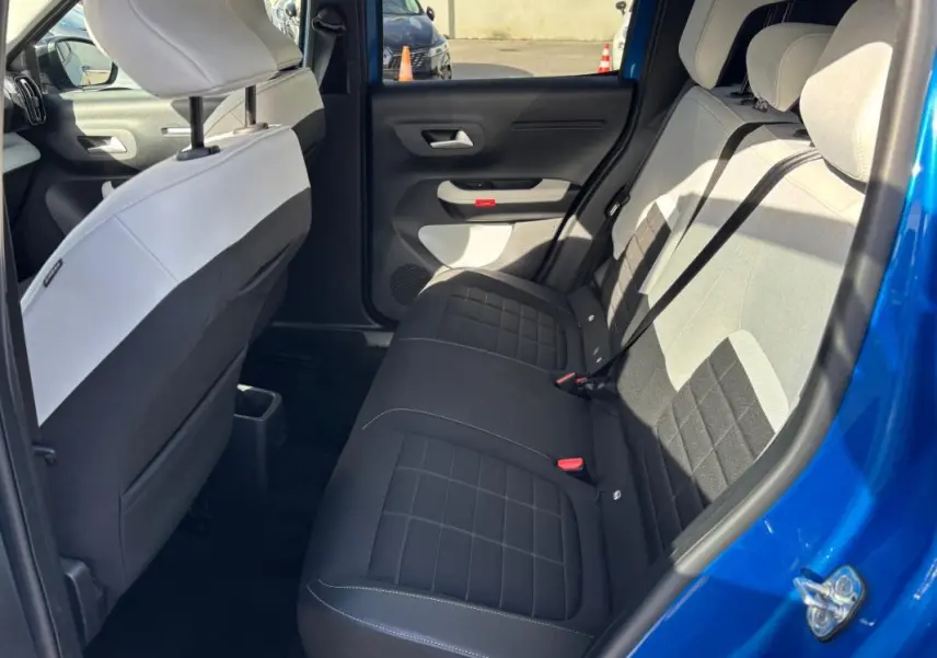Vue intérieure côté droit des sièges arrière noirs et gris d'une Citroën C3 bleu 2025 avec portière ouverte.