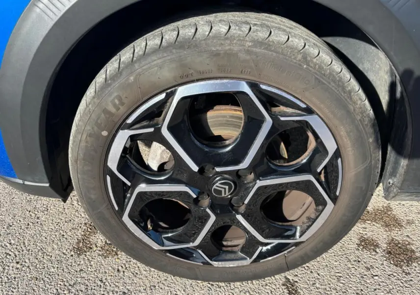 Gros plan sur la jante alliage noire et argentée de 17 pouces d'une Citroën C3 bleu 2025, côté gauche.