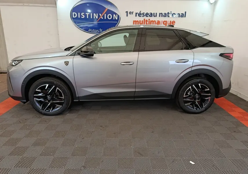 Profil droit du Peugeot 3008 gris clair 2025 avec jantes noires et toit noir contrasté en intérieur showroom.