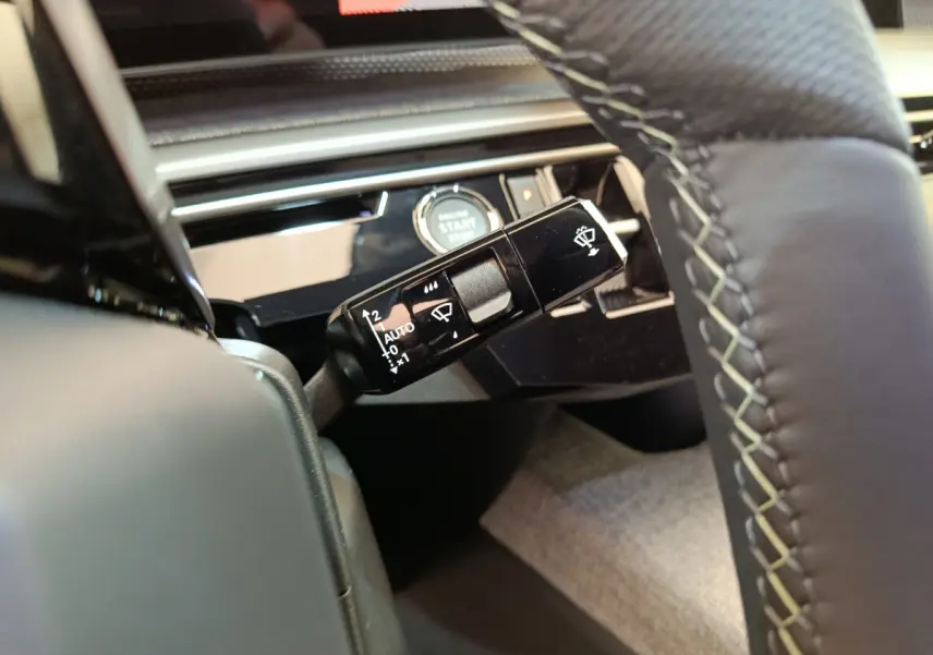 Gros plan sur la commande des essuie-glaces et le bouton start/stop dans l’habitacle du Peugeot 3008 gris clair 2025.