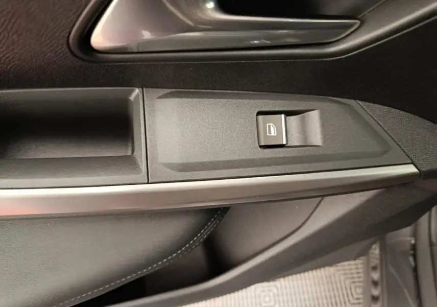 Détail de la porte côté droit du Peugeot 3008 gris clair, montrant la poignée et les commandes de fenêtre.