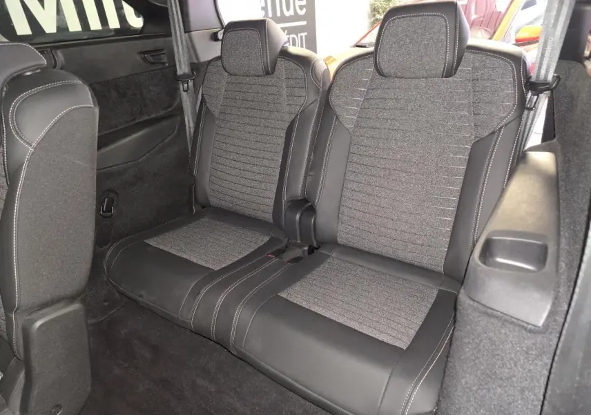 Vue intérieure des sièges arrière 3e rangée en tissu gris et cuir noir du Peugeot 5008 2025 hybride.