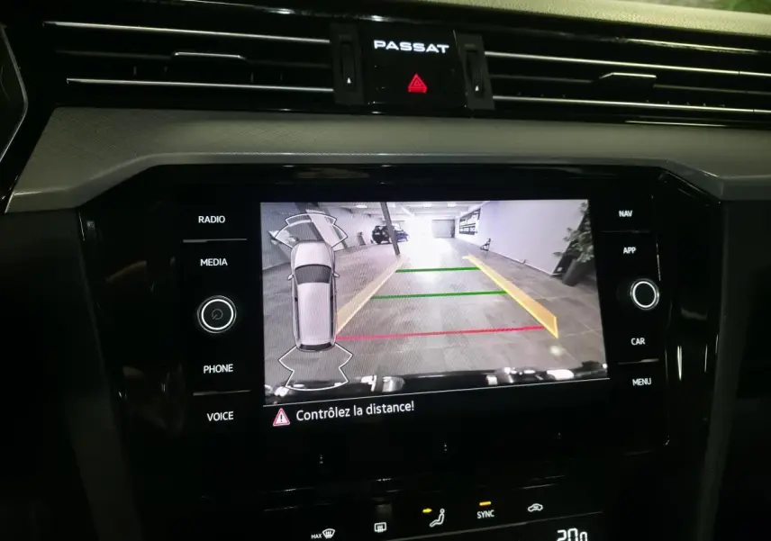 Vue rapprochée de l’écran tactile central de la Volkswagen Passat SW 2024 affichant la caméra de recul avec guidage coloré.