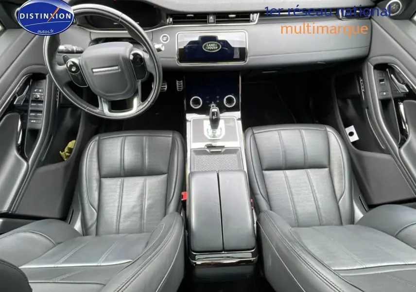 Vue intérieure du Range Rover Evoque 2020 noir, montrant les sièges cuir noirs et la console centrale moderne.
