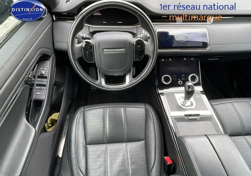 Intérieur noir du Range Rover Evoque 2020, vue plongeante sur le volant, sièges cuir et console centrale moderne.