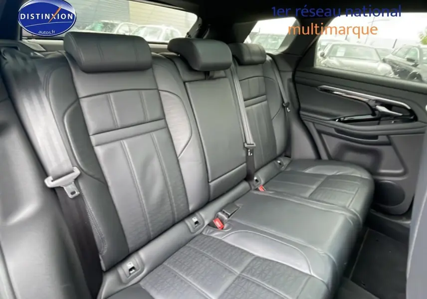 Vue intérieure des sièges arrière en cuir noir du Range Rover Evoque 2020, avec accoudoir central et ceintures visibles.