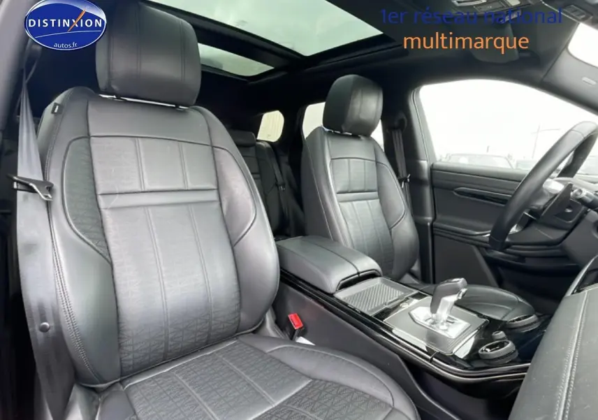Vue intérieure avant du Range Rover Evoque 2020 noir, sièges cuir noirs et toit panoramique coulissant visible.