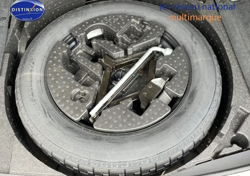 Roue de secours avec outillage intégré dans le coffre d’un Range Rover Evoque noir, vue de dessus.