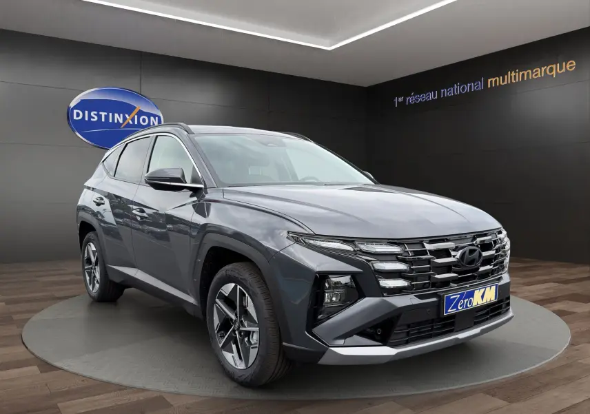 Hyundai Tucson 1.6 Hybrid gris foncé en vue 3/4 avant droit, avec calandre distinctive et jantes modernes.