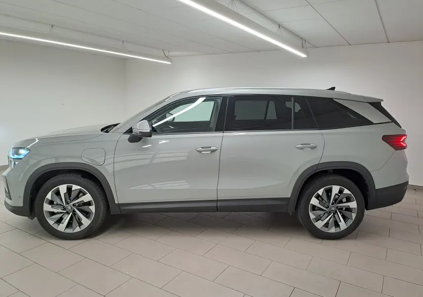 Vue latérale droite d'un Skoda Kodiaq gris perle 2025 avec jantes alliage 19'' et feux arrière allumés.