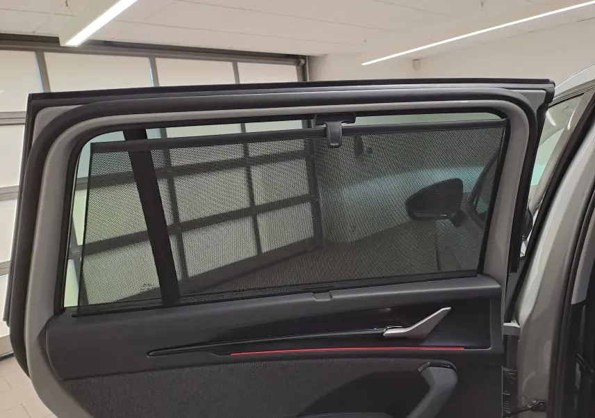 Vue intérieure de la porte arrière droite d’un Skoda Kodiaq gris perle avec pare-soleil intégré et garniture noire.