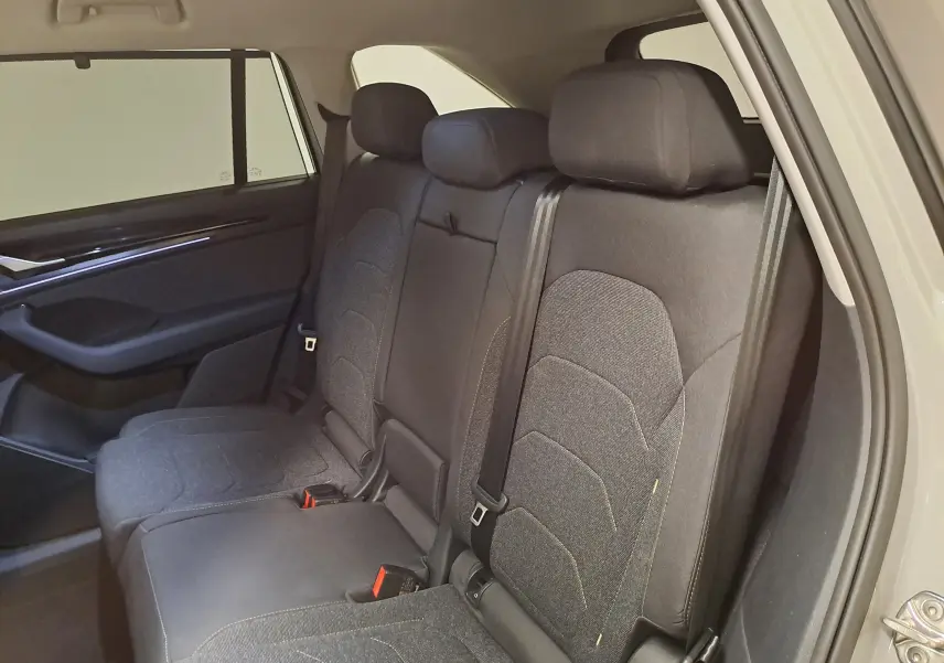 Vue intérieure côté droit des sièges arrière en tissu gris foncé du Skoda Kodiaq 1.5 Hybrid TSI 2025.