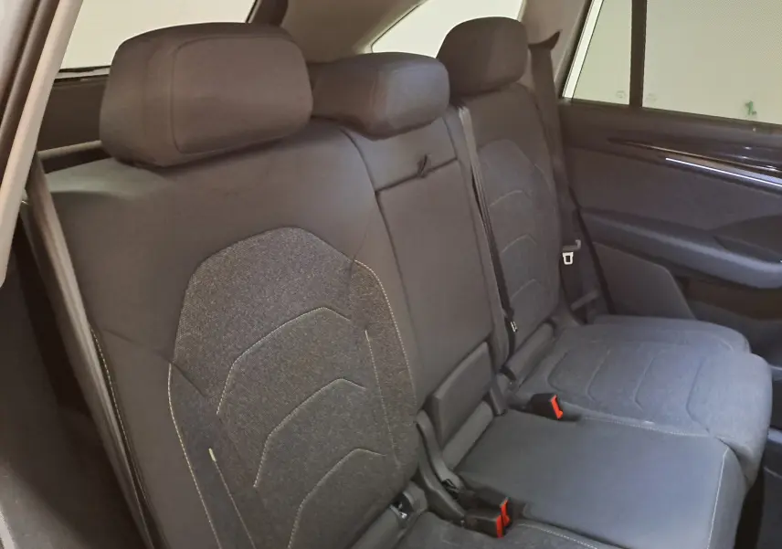 Vue intérieure du siège arrière droit du Skoda Kodiaq 2025, tissu gris avec appuie-têtes et ceinture de sécurité.