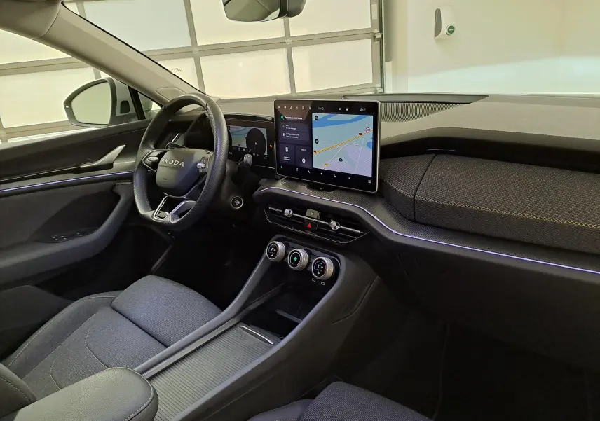 Vue intérieure côté conducteur du Skoda Kodiaq 2025 gris perle, avec écran tactile central et volant multifonction.