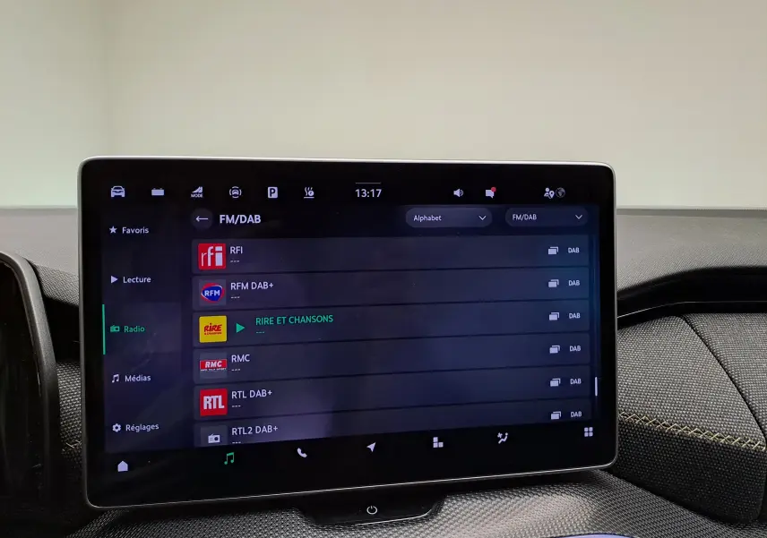 Écran tactile central du Skoda Kodiaq 2025 affichant les stations radio FM/DAB dans un intérieur moderne.