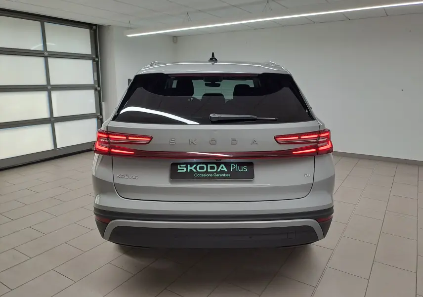 Vue arrière d'un Skoda Kodiaq gris perle avec feux LED allumés dans un garage lumineux.