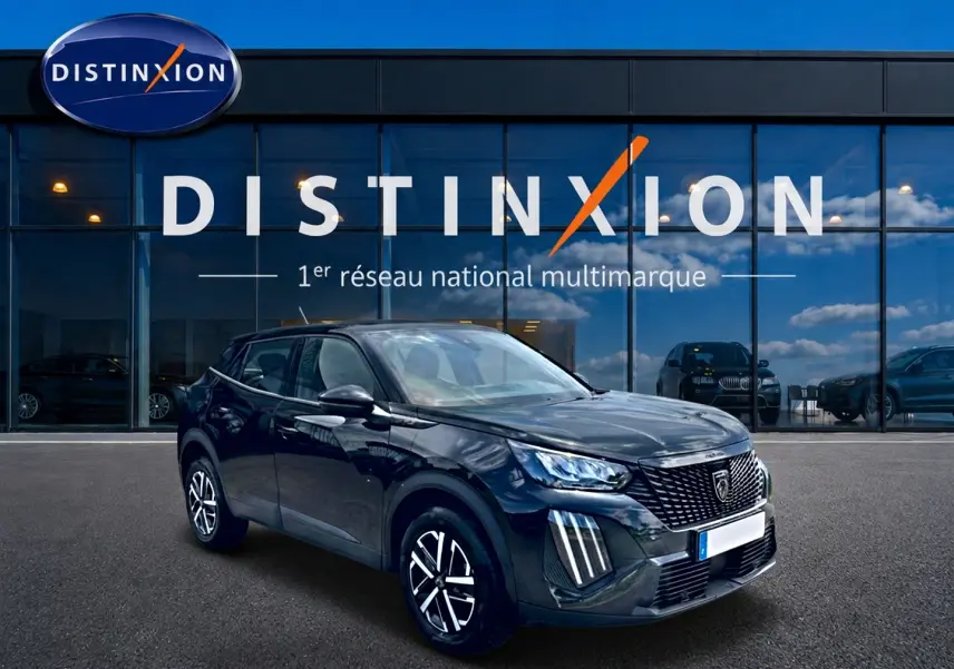 Peugeot 2008 noir en 3/4 avant droit, avec calandre distinctive et feux LED verticalisés, devant showroom Distinxion.