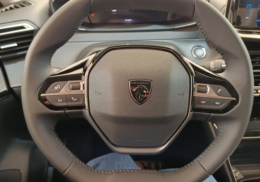 Volant cuir noir Peugeot 208 électrique 2024 vu de face avec commandes multifonctions intégrées.