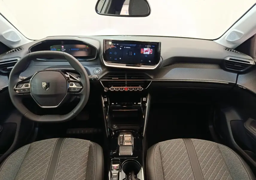 Intérieur de la Peugeot 208 électrique 2024 vu de face, tableau de bord noir avec écran tactile central et volant cuir.