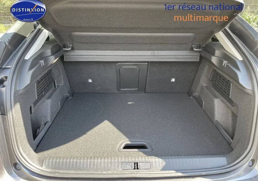 Coffre ouvert vu de l'arrière d'une Citroën C4 gris platinium métal, espace de chargement propre et spacieux.