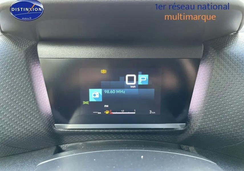 Affichage numérique du tableau de bord de la Citroën C4 gris platinium, montrant la vitesse à 0 km/h et la radio FM.