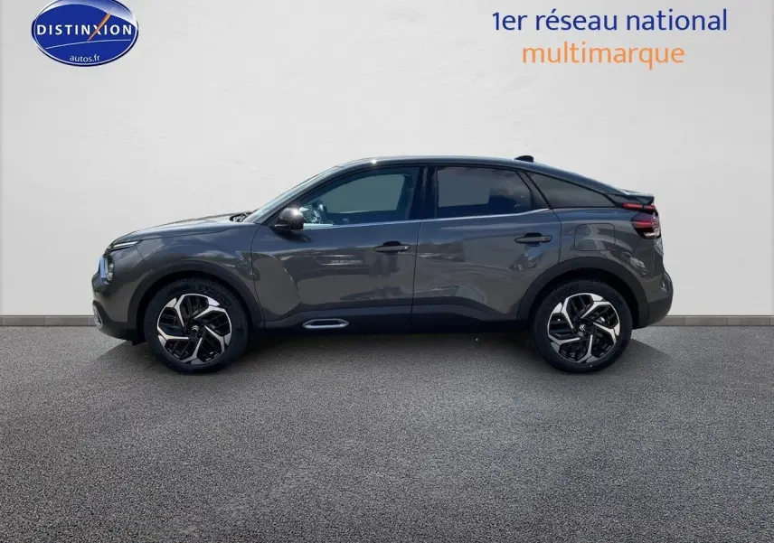 Profil droit d'une Citroën C4 2024 gris platinium métal avec jantes bicolores et toit noir contrasté.